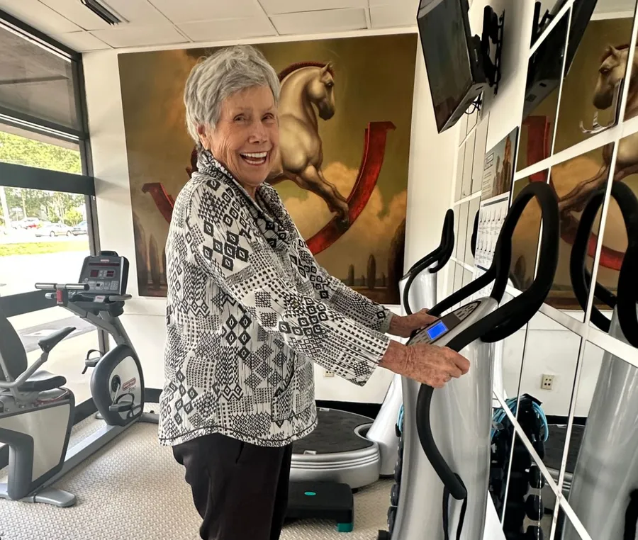 A smiling client on the OxyVibe vibration plate at Citizen OxyWellness